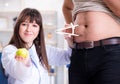 Doctor dietician giving advices to fat overweight patient