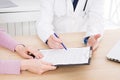 Doctor discusses with female patient medical contract at the clinic, medical insurance