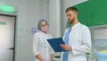 A doctor discusses the patient's medical record with a beautiful nurse.