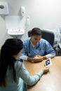 Doctor discussing baby ultrasound report with pregnant woman at hospital Royalty Free Stock Photo