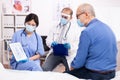 Doctor discussing about bone disease with senior man pointing at tablet pc Royalty Free Stock Photo