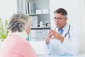 Doctor discussing with female patient wearing neck brace Royalty Free Stock Photo