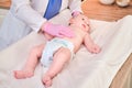 The doctor does gymnastics and massage to a newborn baby. Nurse in uniform doing warm-up exercises to the child Royalty Free Stock Photo