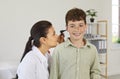 Otolaryngologist examines a happy little boy and uses an otoscope to check his ears Royalty Free Stock Photo