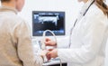 Doctor doing ultrasonic scan on hand of boy Royalty Free Stock Photo