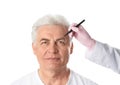 Doctor drawing marks on mature man`s face for cosmetic surgery operation Royalty Free Stock Photo