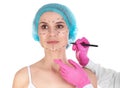 Doctor drawing marks on woman`s face against white background Royalty Free Stock Photo