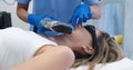 The doctor eliminates defect on a woman's chin with a laser