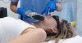 The doctor eliminates defect on a woman's chin with a laser