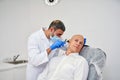 Doctor ENT checking ear with otoscope to man patient at hospital Royalty Free Stock Photo