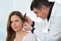 Doctor ENT checking ear with otoscope to woman patient Royalty Free Stock Photo