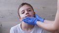 Doctor, ENT in Latex Nitrile Gloves Examines the Ears, Auricle of a Teenager Boy