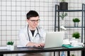 Doctor entering patient notes on a laptop in surgery