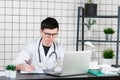 Doctor entering patient notes on a laptop in surgery