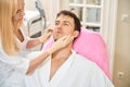 Doctor esthetician examines the patients face Royalty Free Stock Photo