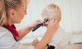 Doctor examines ear with otoscope in a pediatrician room. Royalty Free Stock Photo