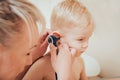 Doctor examines ear with otoscope in a pediatrician room. Royalty Free Stock Photo