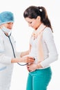 Doctor examines pregnant female using stethoscope Royalty Free Stock Photo
