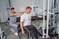 Doctor examines wheelchair man posture in rehab center gym