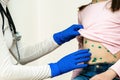 Doctor examining a child covered with green rashes on stomach ill with chickenpox, measles or rubella virus Royalty Free Stock Photo