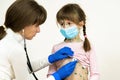 Doctor examining child girl covered with green rashes on face and stomach ill with chickenpox, measles or rubella virus Royalty Free Stock Photo