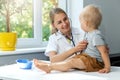 Doctor examining a child patient by stethoscope in clinic office. little boy at pediatrician appointment Royalty Free Stock Photo