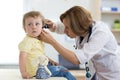 Doctor examining child`s ears in doctor`s office