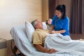 The doctor is examining an elderly patient in a special room. Female doctor examining coughing senior patient in room