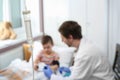 Doctor examining little child in hospital, focus chamber Royalty Free Stock Photo