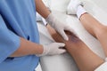 Doctor examining little child`s bruised knee in hospital, closeup Royalty Free Stock Photo