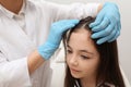 Doctor examining little girl`s hair. Anti lice treatment Royalty Free Stock Photo