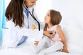 Doctor examining a little girl by stethoscope