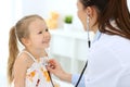 Doctor examining a little girl by stethoscope. Happy smiling child patient at usual medical inspection. Medicine and Royalty Free Stock Photo