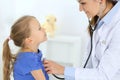 Doctor examining a little girl by stethoscope. Happy smiling child patient at usual medical inspection. Medicine and Royalty Free Stock Photo