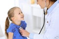 Doctor examining a little girl by stethoscope. Happy smiling child patient at usual medical inspection. Medicine and Royalty Free Stock Photo