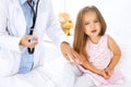Doctor examining a little girl by stethoscope. Patient turned away from his physician Royalty Free Stock Photo