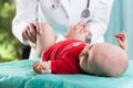 Doctor examining lying baby Royalty Free Stock Photo