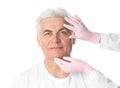 Doctor examining man`s face before plastic surgery operation on white Royalty Free Stock Photo