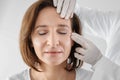 Doctor examining mature woman face before cosmetic surgery Royalty Free Stock Photo