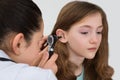 Doctor Examining Patient Ear With Otoscope