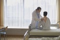 Doctor Examining Patient In Hospital Room