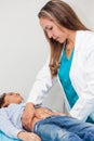 Doctor examining and performing the technique of abdominal percussion to a child Royalty Free Stock Photo