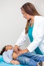 Doctor examining and performing the technique of abdominal percussion to a child Royalty Free Stock Photo
