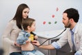 Doctor examining a school boy with his mother at hospital office Royalty Free Stock Photo