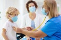 Doctor examining sick child in face mask Royalty Free Stock Photo