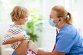 Doctor examining sick child in face mask Royalty Free Stock Photo