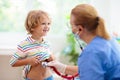 Doctor examining sick child in face mask Royalty Free Stock Photo