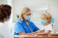 Doctor examining sick child in face mask Royalty Free Stock Photo
