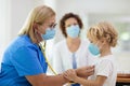 Doctor examining sick child in face mask Royalty Free Stock Photo