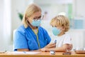 Doctor examining sick child in face mask Royalty Free Stock Photo